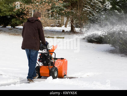 Un uomo lo sgombero neve utilizzando una casa spalaneve. Foto Stock