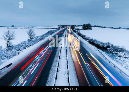 Luce colorata sentieri di più veicoli su New Scenic 5 posti in autostrada in inverno nevoso Foto Stock