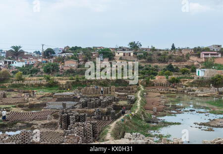 Mattoni sono fatti con il terreno nel campo, riducendo la terra che alimenta la crescita della popolazione. Madagascar, Africa. Foto Stock