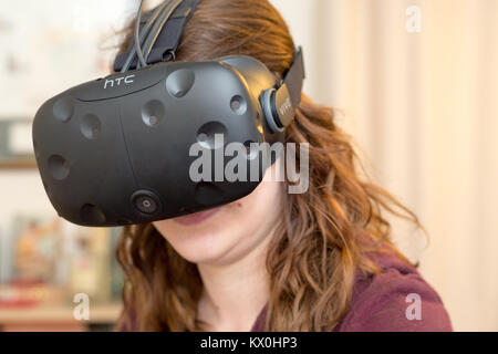 Giovane donna che indossa un VR Virtual Reality auricolare Foto Stock