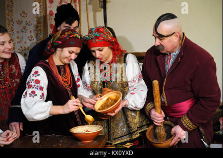 Le persone in costumi nazionali ucraini cucinano piatti tradizionali kutia la vigilia di Natale. 4 gennaio 2018. Kiev, Ucraina Foto Stock