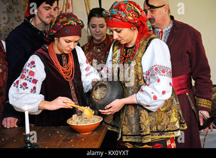 Le persone in costumi nazionali ucraini cucinano piatti tradizionali kutia la vigilia di Natale. 4 gennaio 2018. Kiev, Ucraina Foto Stock