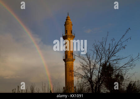 Vista sopra il minareto della moschea Sehidiye e rainbow, in Mardin, Turchia. Foto Stock