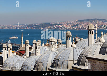 Vista su Istanbul attraverso le cupole e i camini del complesso di Suleymaniye. Foto Stock