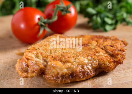 Panate schnitzel (potrebbe essere o vitello, carne di maiale o di pollo cotoletta) su legno Foto Stock