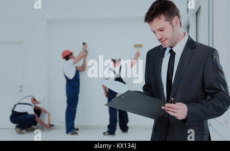 Giovane proprietario controlla i documenti in background della forza lavoro Foto Stock
