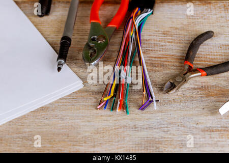 Gli spogliatori di isolamento serie di fili elettrici pinze su sfondo blu il concetto di energia elettrica. Gli spogliatori di isolamento filo elettrico pinze di taglio Foto Stock