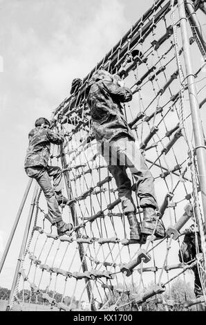 Esercito britannico squaddies sottoposti a formazione di base arrampicarsi sulla corda netting come parte di un percorso ad ostacoli, 15 giugno 1993 Foto Stock