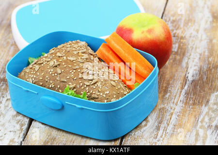 Un sano pranzo al sacco box contenente formaggio marrone sandwich, croccante di carote e Apple Foto Stock