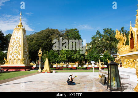 Asian thai donna persone rispetto a pregare la statua di Buddha e chedi di Wat Phra That Nong Bua in Ubon Ratchathani, Thailandia Foto Stock