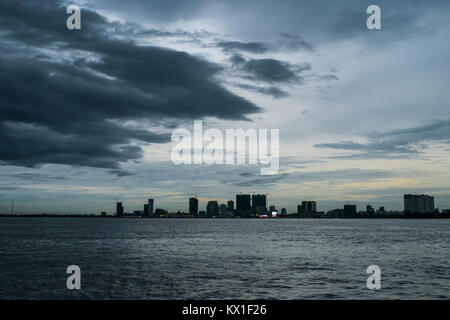 Phnom Penh tramonto tramonto visto dal Mekong e il Tonle Sap fiumi, emergono con sky raschiatori. Stagione dei monsoni e la pioggia nuvole avvicinando alla città Foto Stock