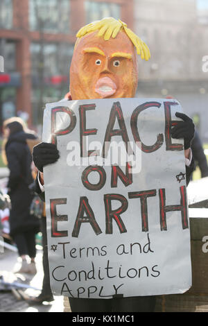 Manchester, Regno Unito. Il 6 gennaio, 2018. Manchester, Regno Unito. Il 6 gennaio, 2018. Un manifestante indossando un atout maschera testa tiene un cartello che recita "la pace sulla terra si applicano termini e condizioni", Manchester, 6 gennaio, 2018 (C)Barbara Cook/Alamy Live News Credito: Barbara Cook/Alamy Live News Foto Stock