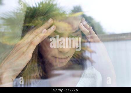 Modello rilasciato. Giovane donna con le mani sul capo. Foto Stock