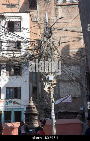 Innumerevoli di energia elettrica e le linee telefoniche sono aggrovigliati insieme su un unico polo utilità nei pressi di Durbar Square, Kathmandu, Nepal. Foto Stock