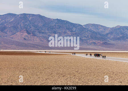 I visitatori sono stati a piedi in Badwater distesa di sale, il punto più basso in Nord America, il Parco Nazionale della Valle della Morte, California, Stati Uniti. Foto Stock