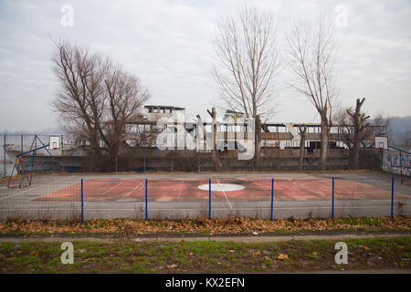 Campo da pallacanestro con un vecchio falling apart nave dal fiume del Danubio a Zemun, Belgrado, Serbia Foto Stock