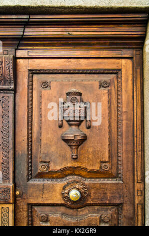 Decorazioni fatte a mano da un artigiano di una antica porta in legno con maniglia Foto Stock