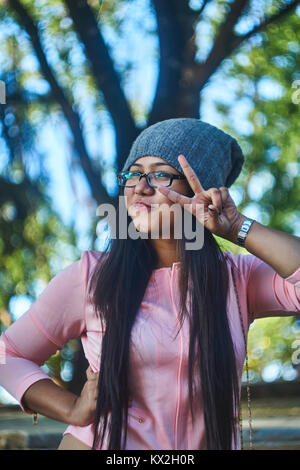 Ragazza sorridente che mostra il simbolo di pace Foto Stock