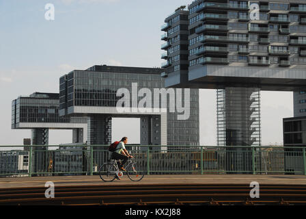 Colonia, Germania - 2 Agosto 2011: ciclista guida su Severin ponte davanti a torri di gru Foto Stock