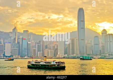 Hong Kong, Cina - 31 dicembre 2016: skyline di Hong Kong e del porto di Victoria con traghetti passando attraverso al tramonto sul dicembre 31, 2016. Foto Stock
