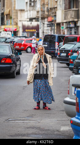 Povertà locale: tipico giù e fuori povera donna in piedi in strada mendicando per Bucarest, la capitale della Romania, Europa centrale Foto Stock