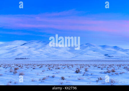 sunrise over snowy hills and sagebrush flats near silver city, montana Foto Stock