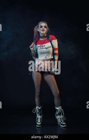 Cosplayer ragazza con in Harley Quinn costume. Halloween make up. Foto Stock