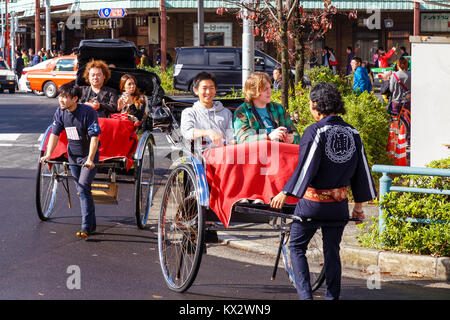 TOKYO, Giappone - 15 novembre 2015: Unidentified rickshaw driver con i passeggeri nella stazione di Asukusa vicino fiume Sumida Foto Stock