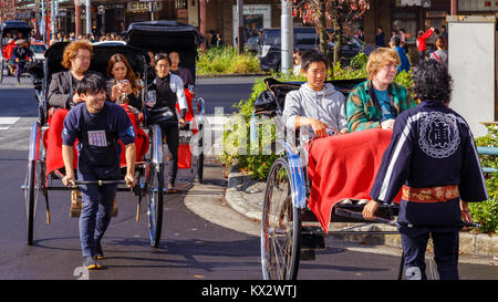 TOKYO, Giappone - 15 novembre 2015: Unidentified rickshaw driver con i passeggeri nella stazione di Asukusa vicino fiume Sumida Foto Stock