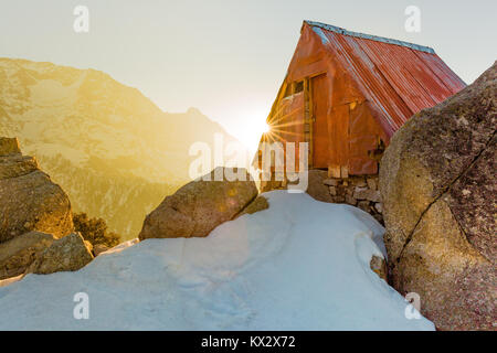 Serene and beautiful Cabin in the snow mountains at Triund hill top, Mcleod ganj, Dharamsala, India during amazing sunrise from behind the mountain Foto Stock