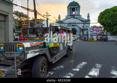 Un trasporto pubblico bus Jeepney in attesa per più passeggeri al di fuori della cattedrale di San Gregorio Magno. Legazpi, Filippine. Foto Stock