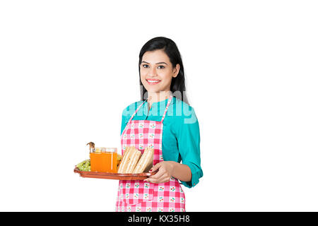 Ritratto di una donna tenendo il vassoio di frutta, succo di frutta, sandwich prima colazione Foto Stock