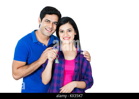 Sorridente sposato-giovane mantenendo le loro nuove chiavi di casa, la proprietà immobiliare Foto Stock