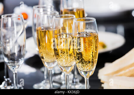 Primo piano di molti bicchieri di champagne in una riga nella tabella delle parti. Occhiali elegante Foto Stock