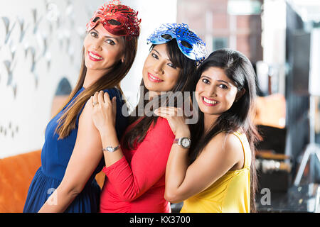 Tre onorevoli amici Stading insieme godendo Capodanno festa per celebrare In-Restaurant Foto Stock