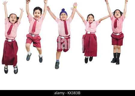 Gruppo indiano per bambini di scuola gli studenti amici Jumping insieme divertendosi Foto Stock