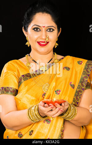 Indian Maharashtrian Lady Diwali celebra tenendo la masterizzazione Diya lampade Foto Stock