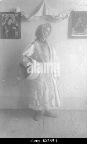 Una fotografia di una donna che indossa un abbigliamento invernale tradizionale, che illustra l'abbigliamento stagionale e le condizioni climatiche fredde. Foto Stock