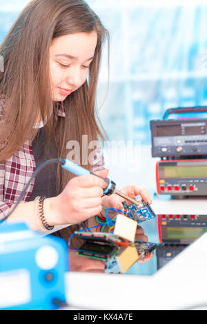 Schoolgirl in robot di laboratorio microcontrollore di debug Foto Stock