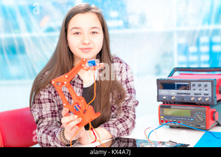 Schoolgirl in robot di laboratorio microcontrollore di debug Foto Stock