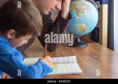 Triste padre stanco di aiutare piccolo figlio in matematica compiti Foto Stock