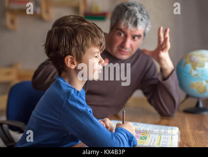 Padre explainn matematica con passione al piccolo figlio pigro Foto Stock