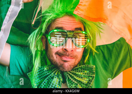 Ritratto di un uomo con la bandiera irlandese indossando san Patrizio accessori Foto Stock