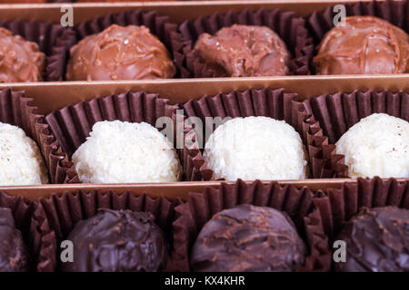 Vicino la vista dettagliata di yummy bianco gustoso, scuro e lattiginosa sfere di cioccolato. Foto Stock