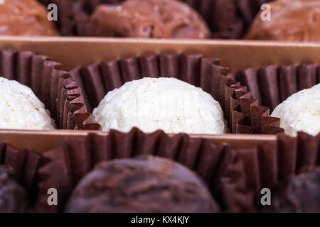 Vicino la vista dettagliata di yummy bianco gustoso, scuro e lattiginosa sfere di cioccolato. Foto Stock