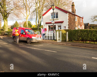 Portalettere raccogliere la posta nel suo furgone dal post office e il negozio del villaggio nel Cheshire village di Dunham Massey greater manchester Foto Stock