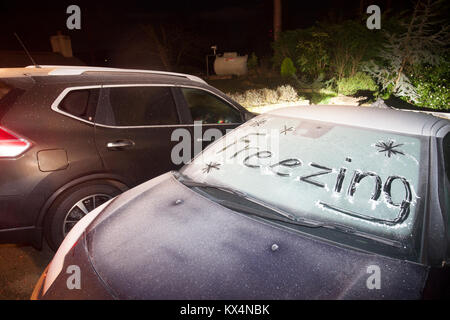 Lixwm, Flintshire, Wales UK Meteo. Anrapid dignitoso a temperatura ha lasciato un grave gelo per tutta la notte in molte parti del Regno Unito tra cui il villaggio di Lixwm in Flintshire con una vettura congelati con le parole scritte di congelamento nel ghiaccio sul parabrezza Foto Stock