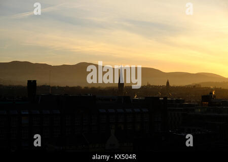 Silhouette della torre e del tramonto su montagne vicino Città Vecchia Edimburgo per un inverno di pomeriggio con cielo nuvoloso, Scozia, Regno Unito il 7 gennaio, 2018. Foto Stock