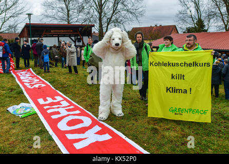 Taubendorf, Germania. Il 7 gennaio, 2018. Un attivista di Greenpeace vestito in un orso polare costume accanto a un banner che recita "Klima schuetzen' (proteggere il clima) a una protesta a piedi contro carbone marrone in Taubendorf, Germania, 7 gennaio 2018. Gli organizzatori dicono circa 300 persone hanno preso parte alla protesta contro il Jaenschwalde carbone marrone miniera a cielo aperto. Credito: Patrick Pleul/dpa-Zentralbild/dpa/Alamy Live News Foto Stock