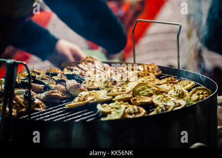 Polacca tradizionale formaggio affumicato (Oscypek) servito alla griglia su barbecue con pancetta, prugna e confettura di frutta a Cracovia il mercatino di Natale. Foto Stock